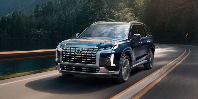 Blue Hyundai Palisade in motion on the road