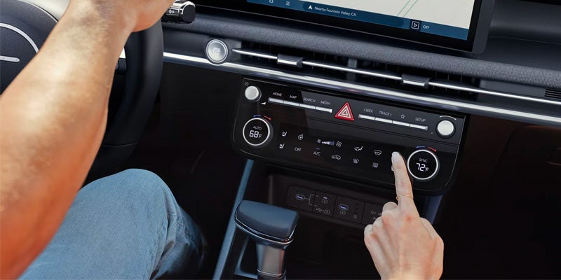 Driver adjusting climate control settings in car