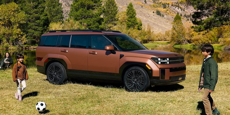 Santa Fe Hybrid parked on ground and kids playing around